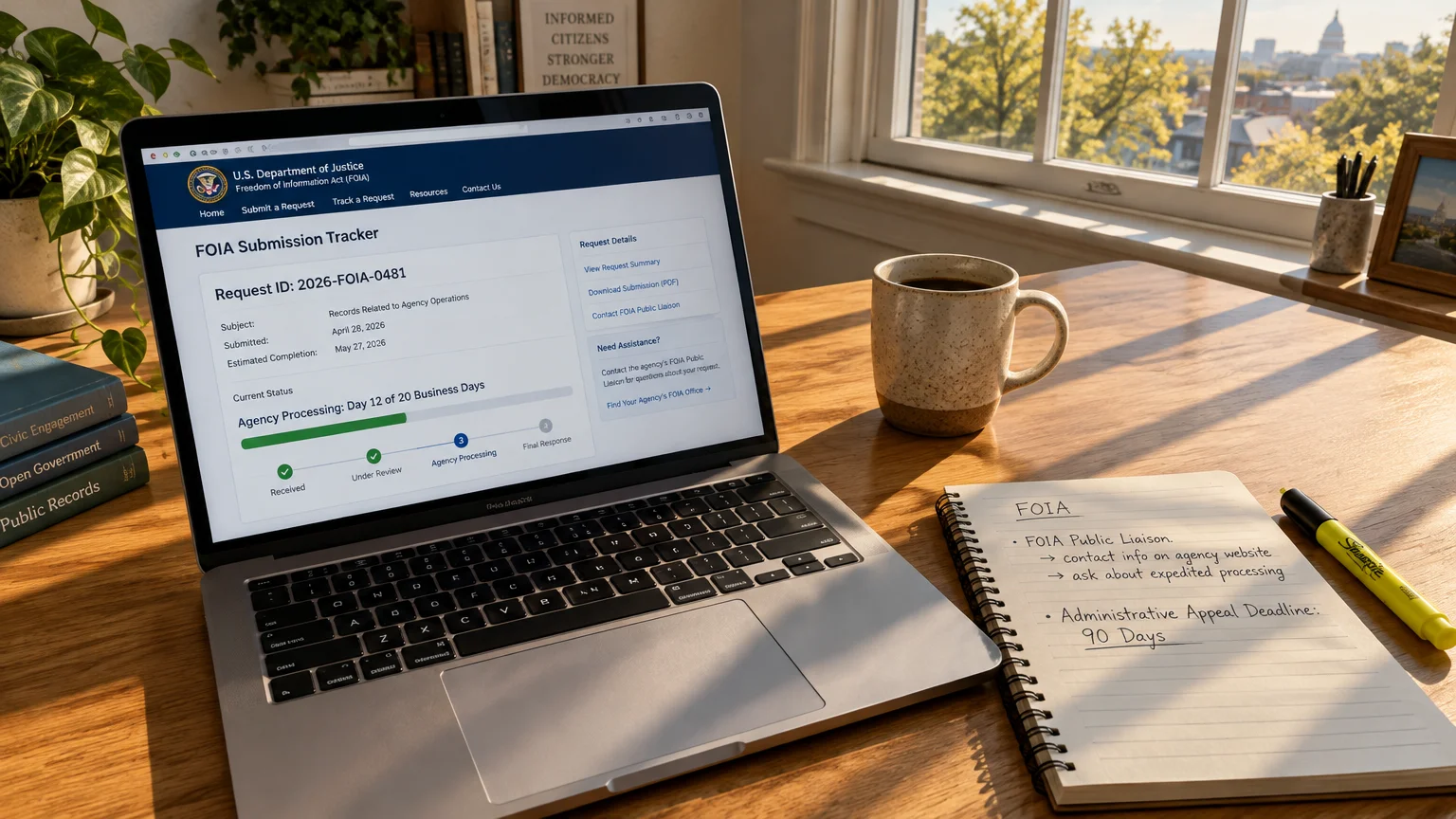 Laptop displaying a DOJ FOIA tracker website beside a coffee mug, pen, and notebook on a sunlit wooden desk.